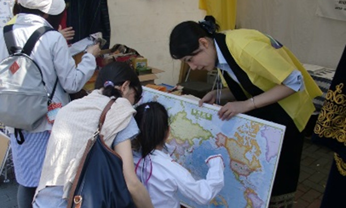 グローバルフェスタでJICE職員が親子の参加者に
世界地図を解説