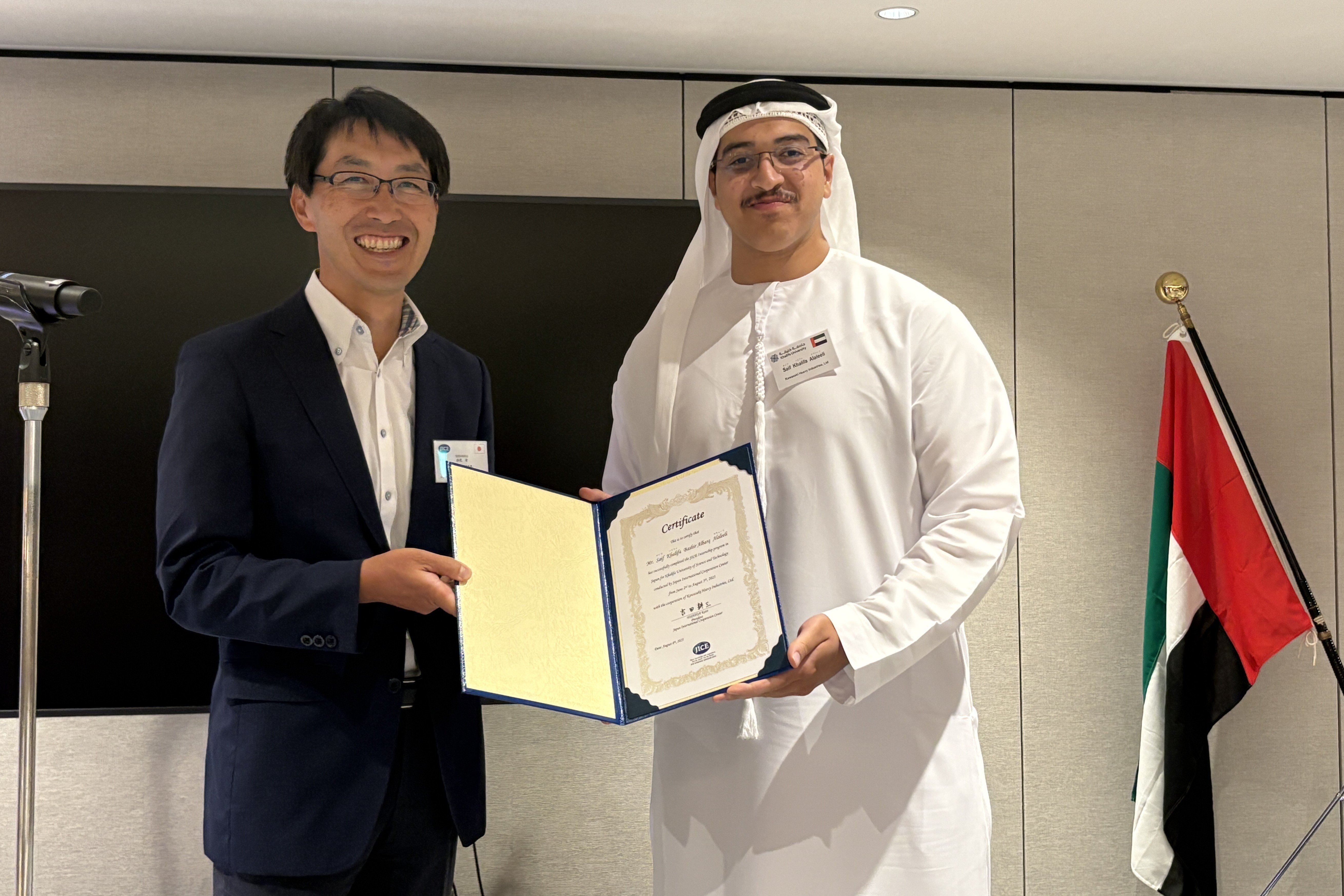 (Left) Mr. AKAO Takashi, Managing Director, International Training Department of JICE -    Presenting the Certificate of Completion to a Participant at the Reporting Session in Japan